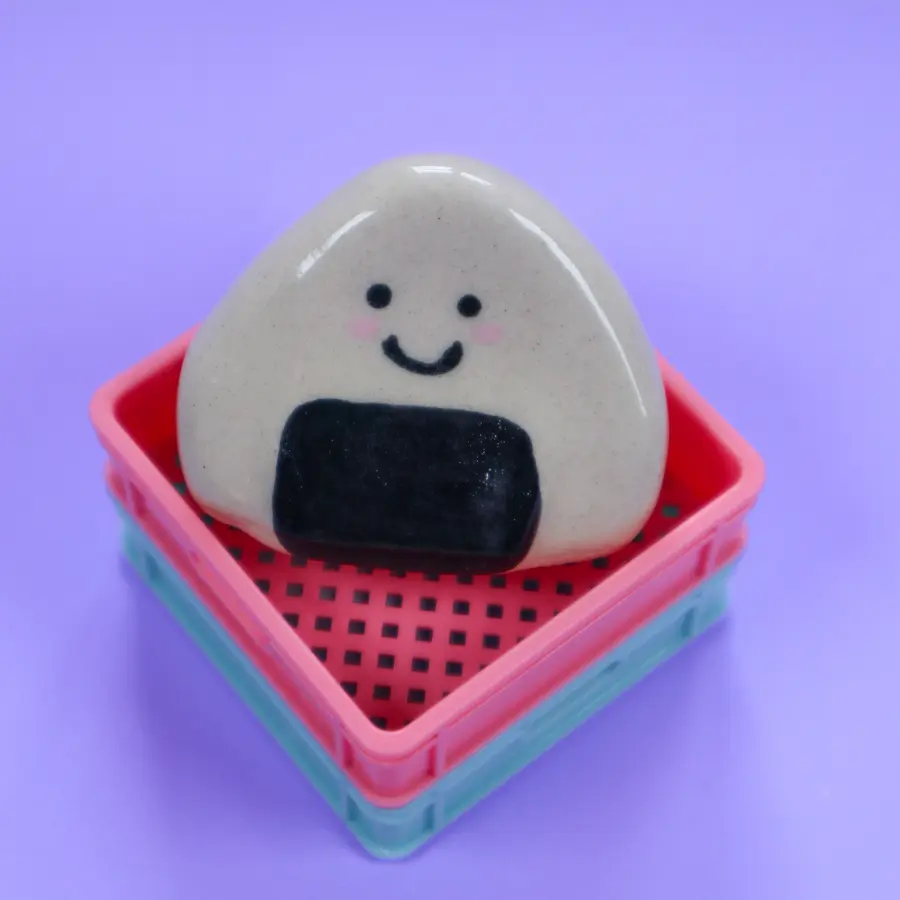 Doudou onigiri en céramique dans un panier rose